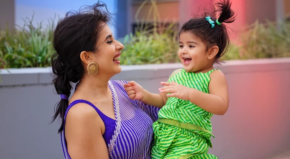A creator laughing with her toddler outdoors